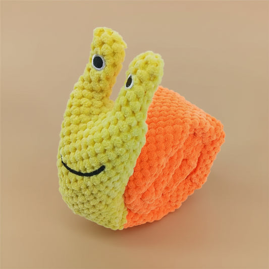 Crocheted snail toy with a smiling face on a white background