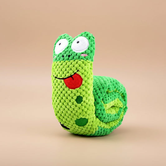 Green crocheted dog toy shaped like a caterpillar with a dog playing with it.