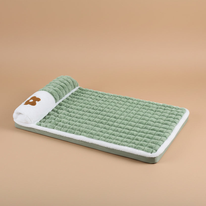 Green pet mat with a white border and brown logo on a beige background