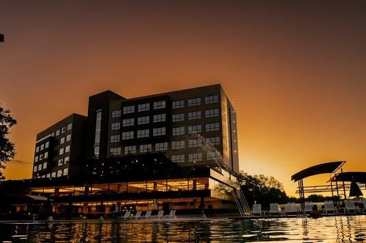 Hotel bathed in sunset colors near a pool.