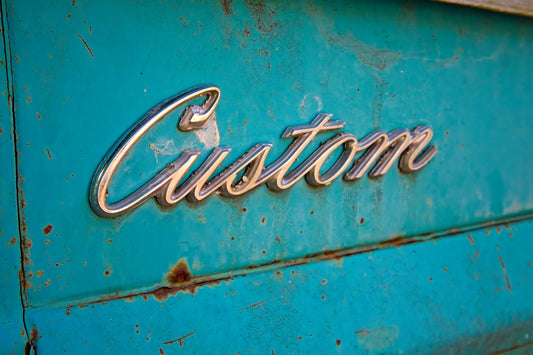 Chrome emblem on rusty teal surface