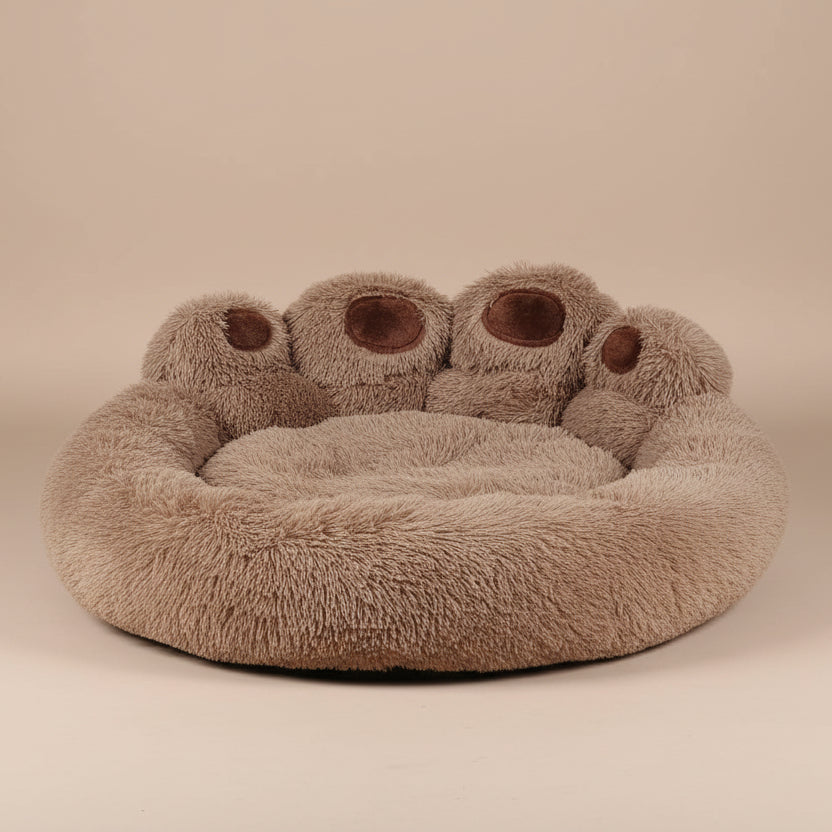 Round, plush pet bed with a bear paw  design on a beige background