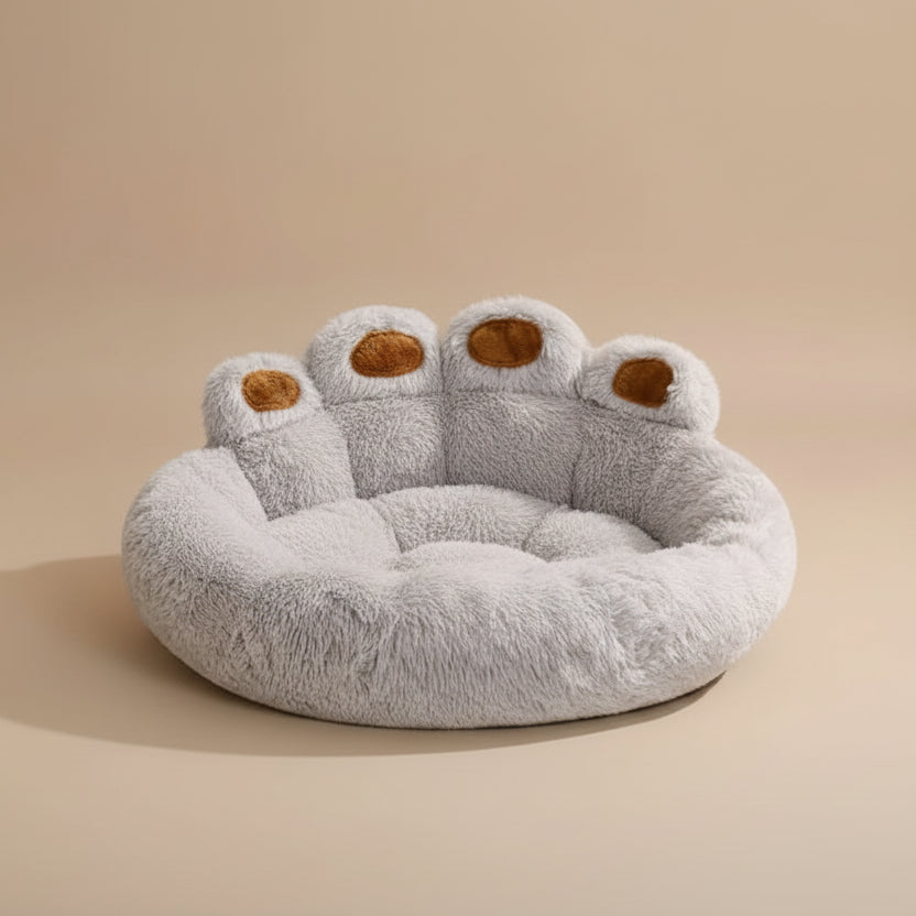 fluffy paw-shaped pet bed with a beige background.