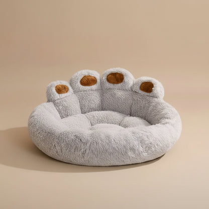 fluffy paw-shaped pet bed with a beige background.
