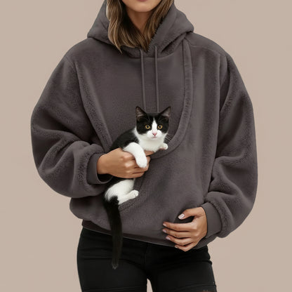 Person wearing a gray hoodie with big pocket, holding a cat.
