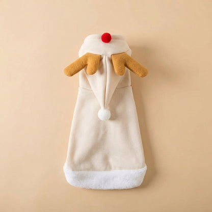 A cream-colored plush Christmas stocking designed to look like a reindeer, featuring yellow-brown antlers, a red nose, and a white fluffy trim at the bottom, displayed on a beige background with styled props.