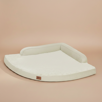 Image of a large, cushioned dog bed with a beige background.
