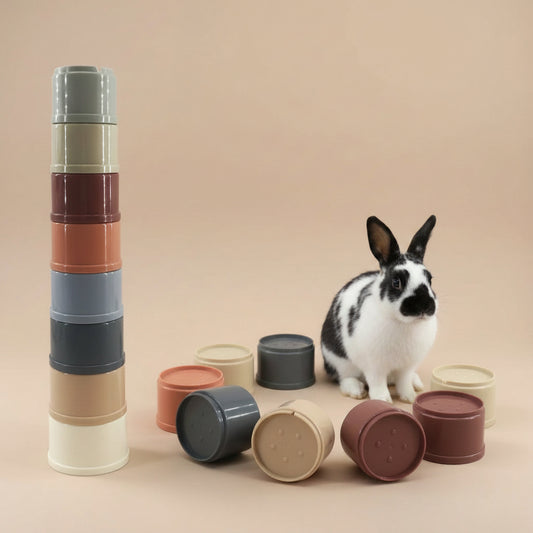 Set of pet stackable toy cups with a black and white rabbit on a beige background