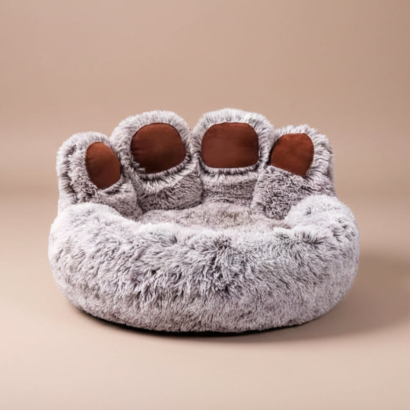 Pet bed shaped like a paw with fluffy texture on a beige background