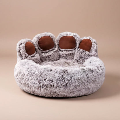 Pet bed shaped like a paw with fluffy texture on a beige background