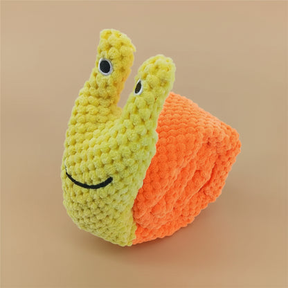 Crocheted snail toy with a smiling face on a white background