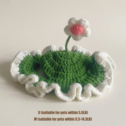 Knitted green heart with white border and pink flower on a beige background