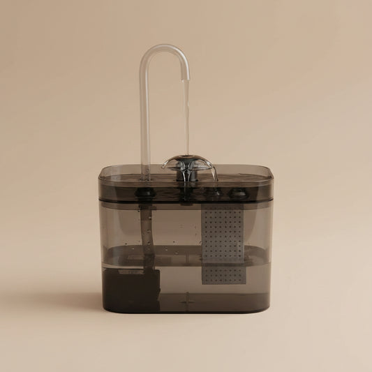 Clear plastic water filter with a hose on a white background