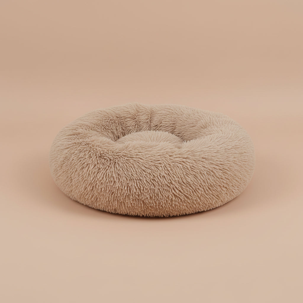 Fluffy beige pet bed on a white surface with a beige background
