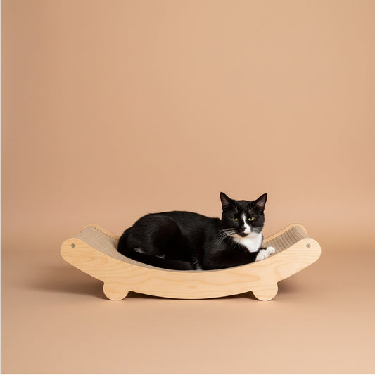 Cat lying on a wooden pet bed with a bed in the background