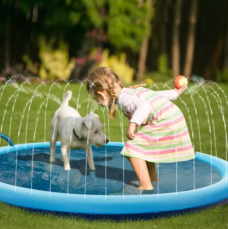 Child playing with a dog in a inflatable pool with water sprays outdoors.