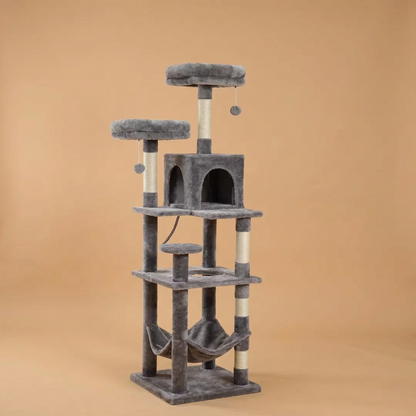 A multi-level cat tree with gray plush carpeting, cream-colored scratching posts, a top perch with a cat lying on it, a central enclosed cat house with a cat inside, a hammock at the bottom, and a hanging toy, shown on a plain white background.