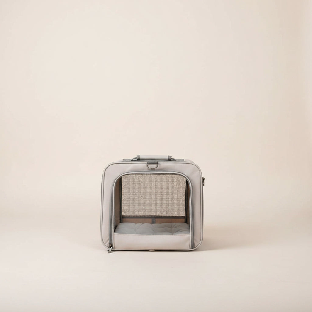 inside a gray mesh pet carrier on a be backgroundge