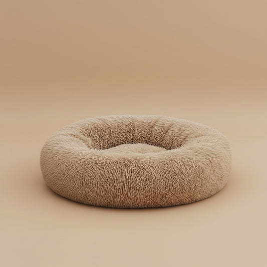 Dog lying on a fluffy beige donut bed on a beige background.