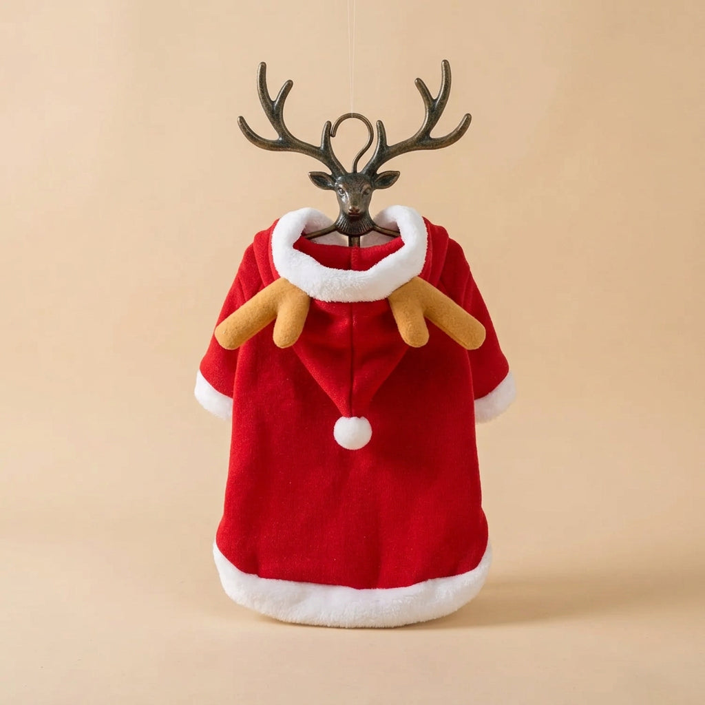 A red plush Christmas cloak with white faux-fur trim and tan reindeer antlers, laid flat on a beige surface.