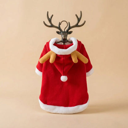 A red plush Christmas cloak with white faux-fur trim and tan reindeer antlers, laid flat on a beige surface.