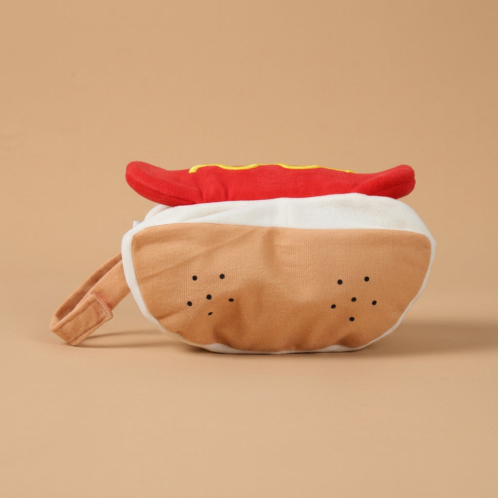 Plush costume shaped like a hot dog with a bun on a beige background