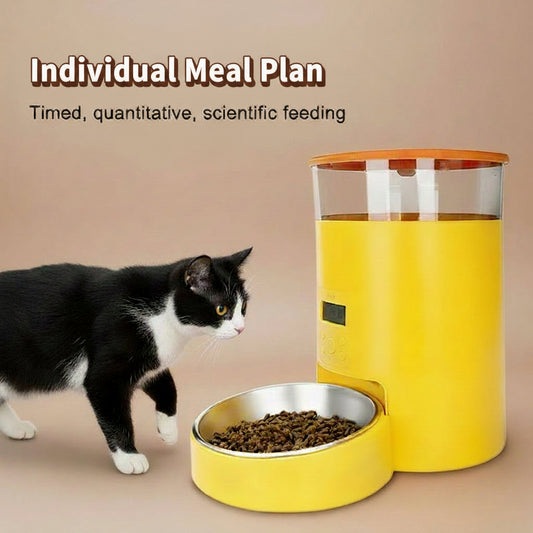 Yellow pet feeder with a bowl of food on a beige background, accompanied by a tuxedo cat.