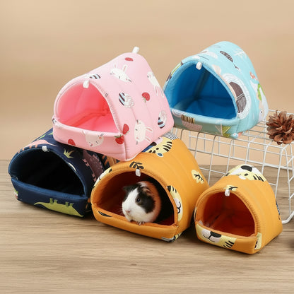 Colorful pet houses with a small animal peeking out on a wooden surface.