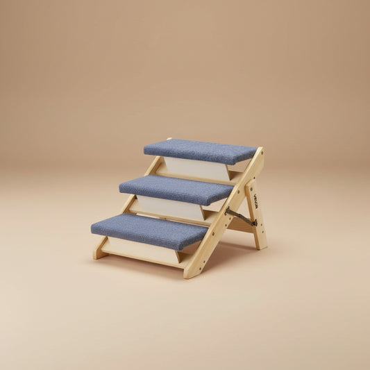 A three-step wooden pet staircase with blue cushioned steps on a white background. 