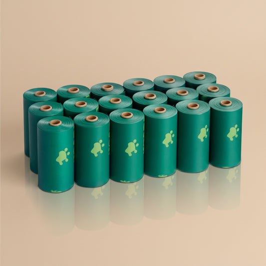 Multiple green waste bag rolls with a logo on a beige background
